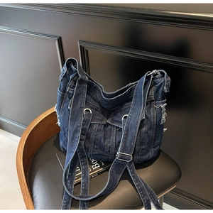 Detail shot of vintage denim tote bag showing retro jean pockets and metal rivets
