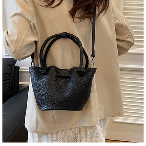Close-up of black lychee texture leather bucket bag with JIDUO & FASHION branding