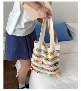 Detailed macro view of handmade striped knit tote bag with colorful 3D floral accents