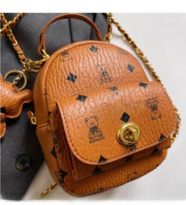 Detailansicht eines braunen Mini-Rucksacks mit Bärenmuster und goldener Ketten-Schultergurt