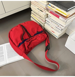 Detail of red water-resistant pleated shoulder bag featuring black drawstring closure