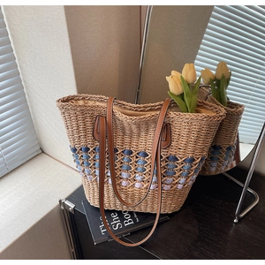 Détail du sac cabas en paille tissé avec rayures colorées et bandoulières en cuir marron