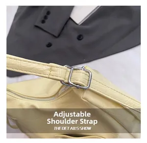 Detail of adjustable shoulder strap with silver buckle on faux crocodile tote bag