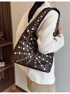 Brown faux leather hobo bag with silver stud rivets and a wide shoulder strap