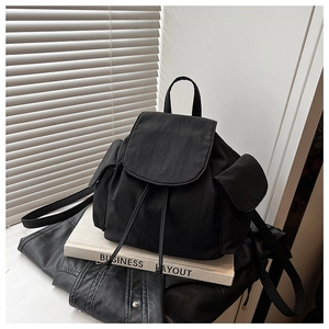 Detail of black nylon backpack with drawstring closure and functional side pockets