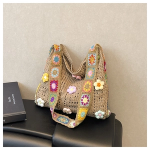 Detail einer handgehäkelten Sonnenblumen-Tasche mit breitem floralem Patchwork-Schultergurt