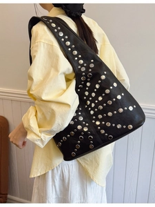 Black hobo bag with silver rivets and wide strap shown from a back view on model