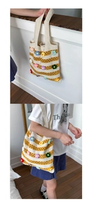 Detail view of woven striped tote bag featuring 3D knitted flower accents and shoulder strap