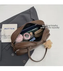 Interior view showing the large capacity of the brown Boston bag with daily essentials