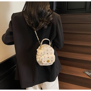 Rückansicht eines Mini-Rucksacks in Weiß mit Bärenmuster und Metallkette am Model getragen