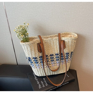 Détail de la texture de tissage dégradé sur ce sac cabas en paille avec anse en cuir