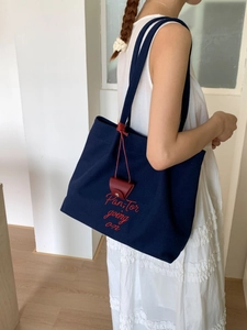 Large navy canvas tote bag with red embroidery and small red shoulder strap pouch