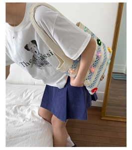 Détail du sac cabas tricoté main avec fleurs 3D colorées et rayures bleues élégantes