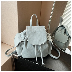Macro shot of light blue canvas backpack featuring crinkled texture and drawstring details