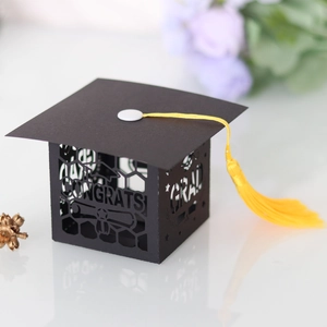 Detailed macro view of laser-cut Congrats Grad text and yellow tassel on black favor box