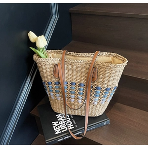 Détails du sac en paille naturelle avec motifs colorés et anses en cuir marron
