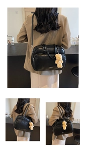 Detail of vintage black leather Boston bag with plush bear charm and white CHERMATE logo