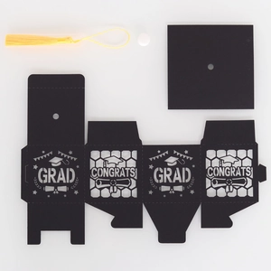 Detail of DIY graduation cap favor box with yellow tassel and cutout congrats pattern