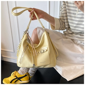 Detail of yellow crocodile pattern hobo bag with buckled pocket and decorative silk scarf