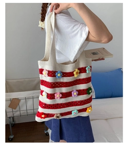 Détail du cabas en tricot rayé rouge et blanc avec fleurs crochetées 3D colorées