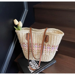 Détail du sac cabas en paille tissée avec texture colorée et anses en cuir marron