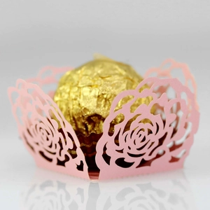 Detail of pink laser-cut rose hollow paper wrapper for wedding candy and truffles