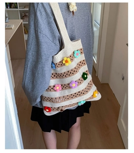 Detailed close-up of striped crochet tote bag featuring colorful 3D knitted flower accents