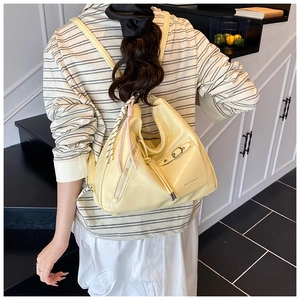 Detail of cream faux crocodile texture backpack with silver zippers and woven charm