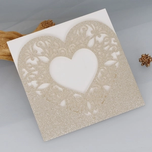 Detailed laser-cut heart pattern on champagne gold glitter invitation card for weddings