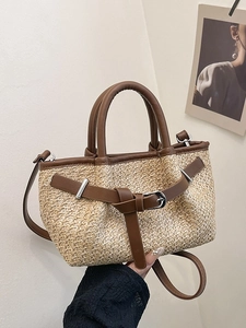 Chic woven straw crossbody beach bag with brown leather handles and buckle strap detailing