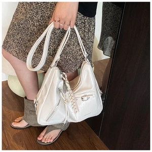 Detail of white crocodile texture tote bag with metal buckle and adjustable strap