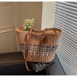 Détail du sac cabas en paille fait main avec motif tissé coloré et anses en cuir marron