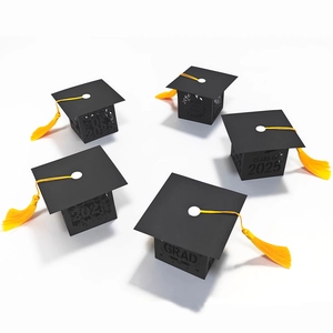 Detail of laser-cut black graduation cap candy boxes with gold tassels and Class of 2025 text