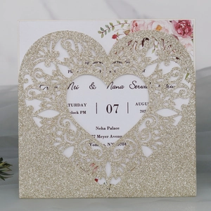 Detail of laser-cut glitter gold heart wedding invitation with elegant floral insert