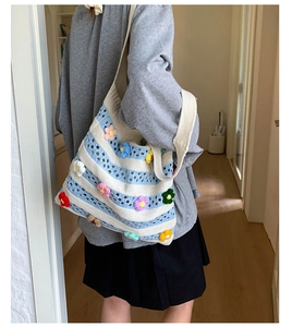 Détail du sac cabas en crochet rayé avec fleurs 3D tricotées et large bandoulière
