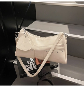 Detail of off-white PU shoulder bag with heart pendant and silver rivet pockets