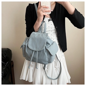 Detail of light blue canvas backpack with drawstring closure and fine stitching textures