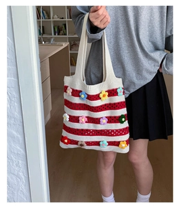 Détail du sac cabas en tricot rayé rouge et blanc avec des fleurs au crochet colorées