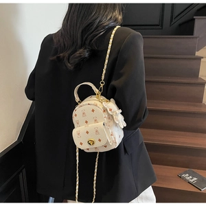 Rückansicht eines weißen Mini-Rucksacks mit Bärenprint, Goldkette und Schleifendetail