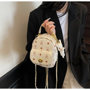 Detailansicht des beigen Rucksacks mit Bärenmuster und goldenem Drehverschluss-Design
