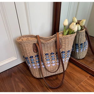 Détail du sac cabas en paille avec losanges bleus et fines anses en similicuir marron