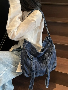 Retro washed denim tote bag with long ribbons and side pockets on model shoulder