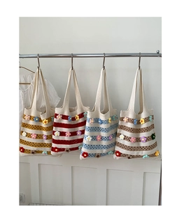 Détail de quatre sacs fourre-tout au crochet rayés avec décorations florales 3D à la main