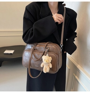 Brown vintage pillow bag with CHERMATE logo and cute bear pendant on a model