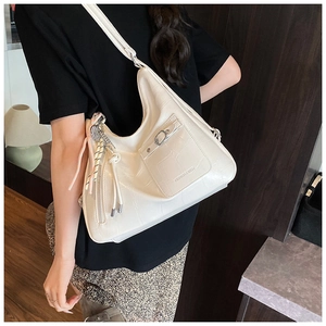 Detail of off-white tote bag with crocodile pattern and decorative side drawstrings