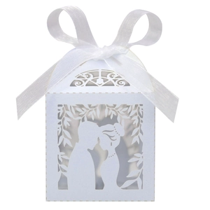 Detail of laser-cut wedding candy box featuring a bride and groom silhouette with ribbon