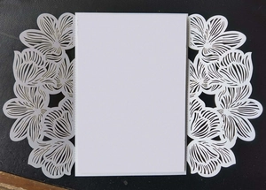 Detailed laser-cut white wedding invitation card with elegant floral hollow pattern