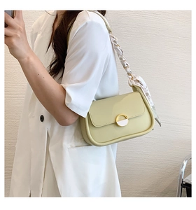 Détail du sac de selle vert clair avec poignée en foulard de soie et boucle en métal