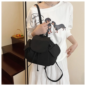 Detail of minimalist black nylon drawstring backpack with side pockets on model