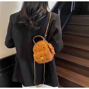 Detailansicht Mini-Rucksack aus karamellbraunem Leder mit klassischem Muster und Drehverschluss